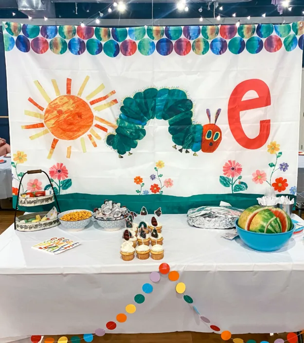 A Very Hungry Caterpillar themed cake table set up in the party room