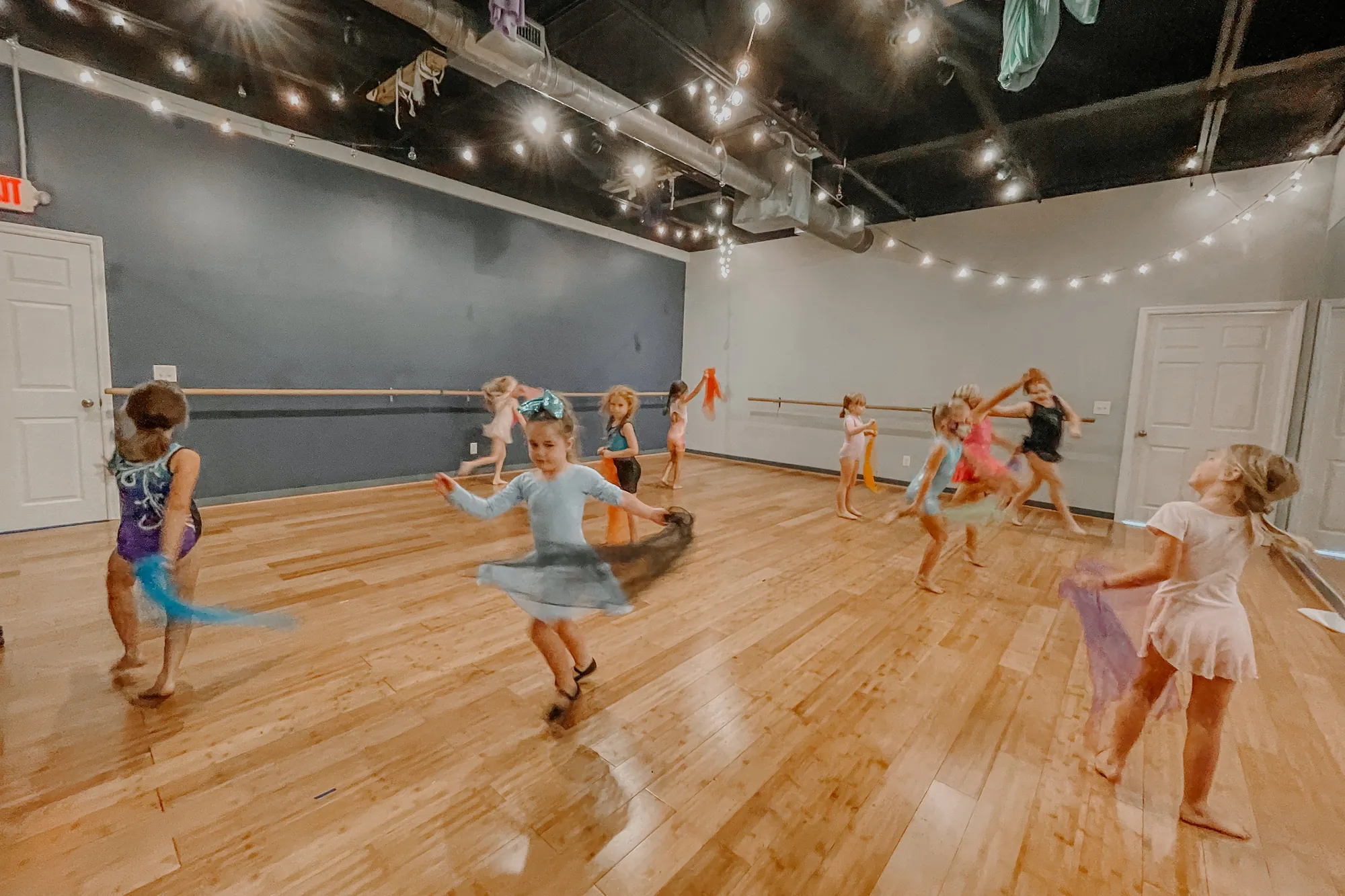 Kids dancing with colorful scarves in the dance studio